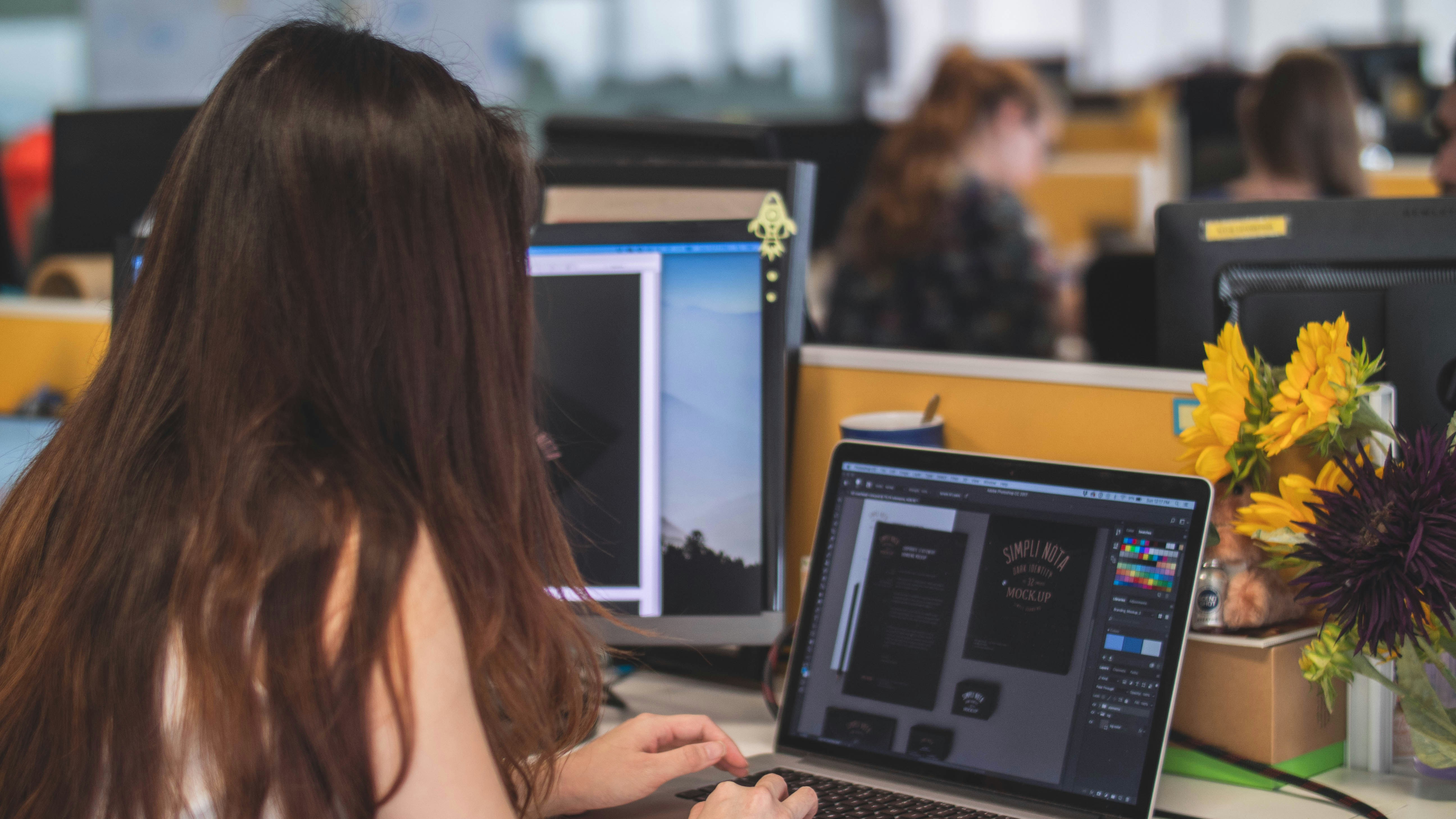 Sideview of a girl while editing on laptop
